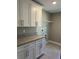 Laundry room with modern cabinets, granite countertop, and utility shelf at 1621 Pear Ave, Sanford, FL 32771