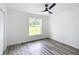 Bedroom with wood-look floors, large window, and ceiling fan at 22474 Sw Rainbow Lakes Blvd, Dunnellon, FL 34431