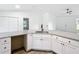 L-shaped kitchen with granite countertops and white cabinets at 22474 Sw Rainbow Lakes Blvd, Dunnellon, FL 34431