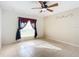 Bedroom with ceiling fan, window with curtains, and tile floor at 2360 Newmark Dr, Deltona, FL 32738