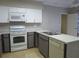 Bright kitchen features white appliances and gray cabinets at 237 S Shadowbay Blvd, Longwood, FL 32779