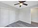 Bedroom with ceiling fan, grey flooring, and double door closet at 805 Willow Ave, Sanford, FL 32771