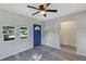 Living room with gray walls, gray flooring, and blue door at 805 Willow Ave, Sanford, FL 32771