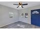Living room with gray walls, gray flooring, and blue door at 805 Willow Ave, Sanford, FL 32771