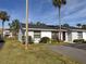 White single-story home with dark gray roof and landscaping at 95 Lake Villa Way, Kissimmee, FL 34743