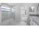 Marble tiled bathroom with glass shower, modern vanity, and doorway to bedroom at 10632 Whitestone Ct, Orlando, FL 32817