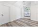 Bright bedroom featuring wood-look flooring, arched window, hanging light fixture, and white trim at 10632 Whitestone Ct, Orlando, FL 32817