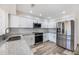 Modern kitchen featuring stainless steel appliances, white cabinets, and granite countertops at 10632 Whitestone Ct, Orlando, FL 32817