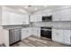 Modern kitchen featuring stainless steel appliances, white cabinets, granite countertops, and grey flooring at 10632 Whitestone Ct, Orlando, FL 32817
