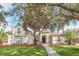 Tan house with palm trees and a brick walkway at 1610 Conway Isle Cir, Belle Isle, FL 32809