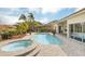 Relaxing pool and spa area with brick pavers and lush landscaping at 1610 Conway Isle Cir, Belle Isle, FL 32809