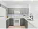 Modern kitchen with gray cabinets and white appliances at 3175 Feltrim Pl # 305, Kissimmee, FL 34747