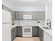 Modern kitchen featuring gray cabinets, white appliances, and quartz countertops at 3175 Feltrim Pl # 305, Kissimmee, FL 34747