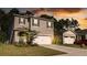 Two-story house with gray siding, white garage door, and blue shutters at dusk at 368 Pelham Park Dr, Deland, FL 32720