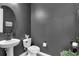 Modern powder room with a pedestal sink and dark gray walls at 4360 Sunset Preserve Blvd, Orlando, FL 32820