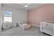 Cozy bedroom with a daybed and crib, pink accent wall at 4360 Sunset Preserve Blvd, Orlando, FL 32820