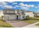 Two-story house with solar panels, three-car garage, and landscaped yard at 4360 Sunset Preserve Blvd, Orlando, FL 32820