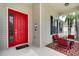 Inviting front porch with red door and seating area at 4973 Pall Mall W St, Kissimmee, FL 34758