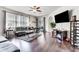 Spacious living room with hardwood floors, sectional sofa, and large TV at 4973 Pall Mall W St, Kissimmee, FL 34758