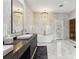 A luxurious bathroom features marble walls, a freestanding tub, dual vanities, and elegant chandeliers at 6025 Lady Bet Dr, Orlando, FL 32819