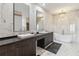Spa-like bathroom with double vanities, a soaking tub, and marble floors at 6025 Lady Bet Dr, Orlando, FL 32819