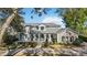 Stately home featuring a manicured lawn, covered entry, and traditional architectural details at 6025 Lady Bet Dr, Orlando, FL 32819