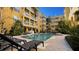 Community pool with lounge chairs and yellow building backdrop at 860 N Orange Ave # 118, Orlando, FL 32801