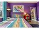 Purple bedroom with large bed, colorful bedding, and a full length mirror at 1021 Siena Park E Blvd # 103, Kissimmee, FL 34747