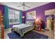 Spacious bedroom with purple walls, a large bed, and plenty of natural light at 1021 Siena Park E Blvd # 103, Kissimmee, FL 34747