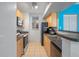 Kitchen with light wood cabinets, black countertops, and stainless steel appliances at 1021 Siena Park E Blvd # 103, Kissimmee, FL 34747