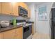 Kitchen boasts light wood cabinets, a white stove, and black countertops at 1021 Siena Park E Blvd # 103, Kissimmee, FL 34747