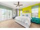 Bright bedroom with yellow accent wall, king-size bed, and ceiling fan at 1261 Radiant St, Reunion, FL 34747