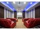 Upscale home theater with red recliner seating, projector, and large screen at 1261 Radiant St, Reunion, FL 34747