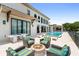 Fire pit and lounge seating area with pool in background at 1261 Radiant St, Reunion, FL 34747