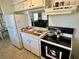 Functional kitchen with white appliances and ample counter space, opening to living area at 1456 N Page Dr, Deltona, FL 32725