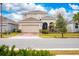 Two-story house with tan siding, a two-car garage, and a brick paver driveway at 285 Miro Dr, Davenport, FL 33837