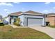 Single story house with gray siding, attached garage, and basketball hoop at 3205 Whispering Trails Ave, Winter Haven, FL 33884