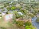 Community aerial showcasing the pool and tennis courts surrounded by homes and lush greenery, complete with parking areas at 4008 Crossroads Pl, Casselberry, FL 32707