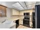 Well-lit kitchen with tile floors, black appliances, and plenty of cabinet space at 4008 Crossroads Pl, Casselberry, FL 32707