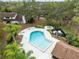 Aerial view of a community pool featuring clear blue water and surrounding manicured landscaping with a hot tub and lounge seating at 4008 Crossroads Pl, Casselberry, FL 32707
