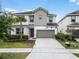 Two-story house with gray siding, two-car garage, and driveway at 418 Marcello Blvd, Kissimmee, FL 34746