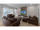 Spacious living room with brown leather sofas and large TV at 418 Marcello Blvd, Kissimmee, FL 34746