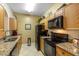 Galley kitchen with granite countertops and black appliances at 8103 Coconut Palm Way # 105, Kissimmee, FL 34747