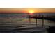 Serene sunset view of a calm lake and a dock at 110 Cypress Woods Ct # 5C, Deltona, FL 32725