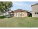 Home with a grassy backyard, patio, and sliding glass doors at 12755 Oulton Cir, Orlando, FL 32832