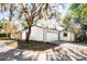 Charming home with a spacious two-car garage and a paver driveway, surrounded by mature trees and beautiful landscaping at 203 Red Bud Ln, Longwood, FL 32779