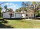 Quaint single-story home with lush front lawn and mature landscaping, providing privacy and curb appeal at 203 Red Bud Ln, Longwood, FL 32779