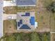 Aerial view of a house with solar panels on the roof and a large backyard at 208 Goldenrod Ln, Kissimmee, FL 34759