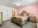 Elegant bedroom with a large bed, ornate furniture, and soft pink walls at 208 Goldenrod Ln, Kissimmee, FL 34759