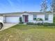 Single-story house with attached garage, solar panels and manicured lawn at 208 Goldenrod Ln, Kissimmee, FL 34759